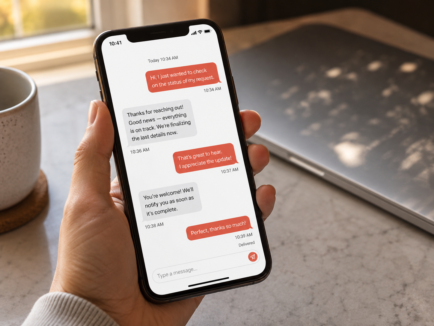Smartphone displaying a short customer message thread with a service business above a countertop